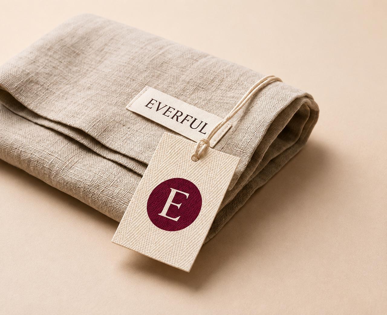 A branded hang tag and label finishing a wholesale product, photographed on a stone surface.