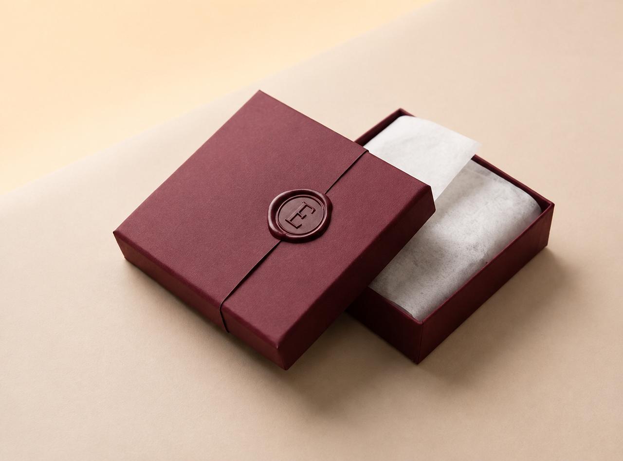 Branded packaging for a wholesale order, styled as a polished unboxing moment on a stone surface.