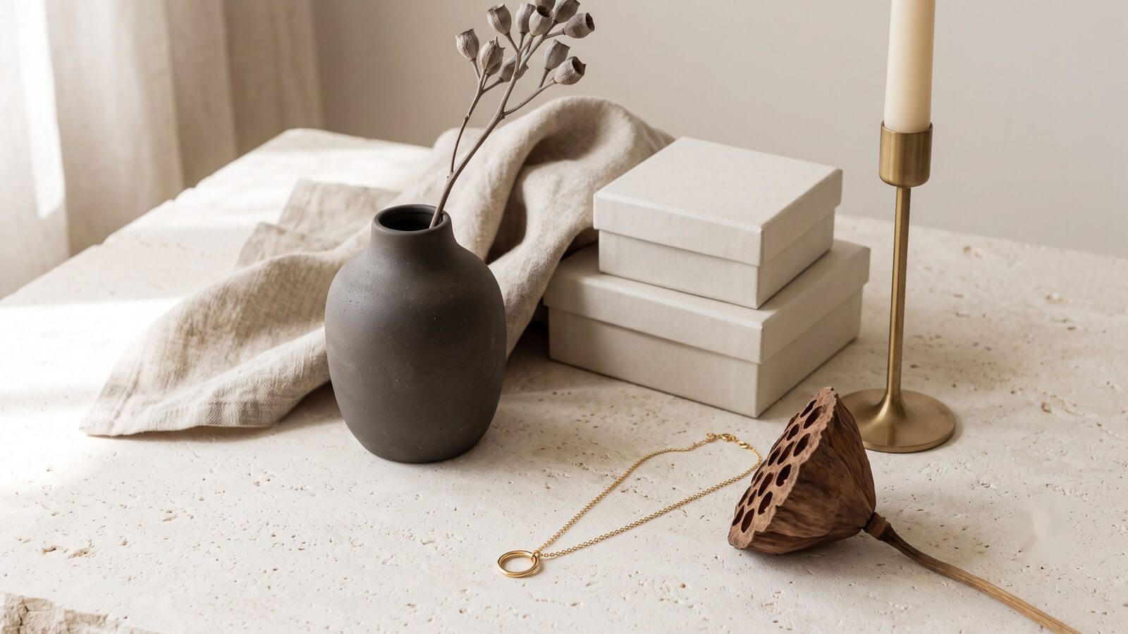A considered grouping of products reading as volume without clutter, on a stone surface.