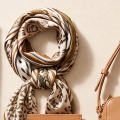 A printed silk scarf and a card holder on a stone surface
