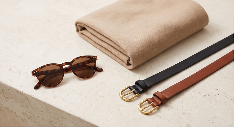 Sunglasses, a folded sweater and leather belts