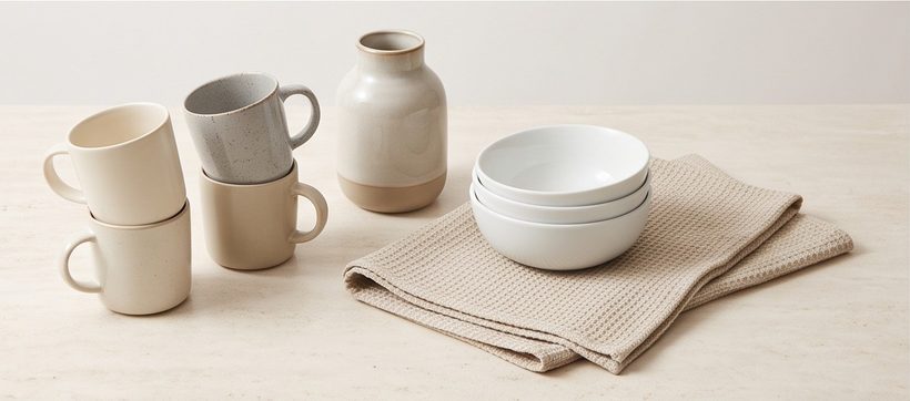 Ceramic mugs, a vase, bowls and a tea towel